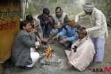 Indian Men Warm Themselves Around Bonfire At A Road In New Delhi Amid Dense Fog