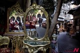 Egyptians Walking In A Street Seen Reflected In Mirrors Of Furniture Displayed On Sale In Cairo