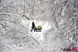 A woman walks snow-covered park with her kid in Moscow
