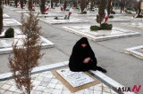 An Iranian woman remembers a soldier killed in Iran-Iraq war at cemetery in Mashhad