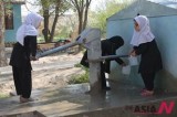 Afghan female students take water from a pump at school in Balkh