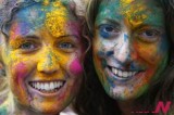 Tourists smear their faces with colored powder to celebrate Hindu festival of Holi