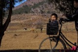 A N. Korean boy rides in bike’s basket as spring flowers bloom
