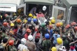 A survivor of Bangladeshi building collapse carried into ambulance