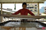 A Nepalese woman makes handmade paper used by government