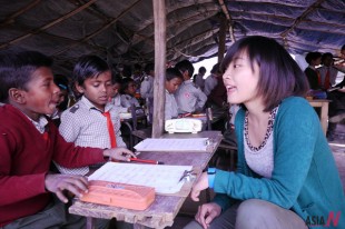 A Chinese volunteer talks to her students at a slum school in northern Indian state of Haryana, Feb. 17, 2012.