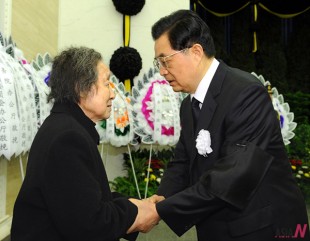 Chinese President Hu Jintao (R) shakes hands with a relative of Zhu Guangya, a renowned nuclear physicist and one of the key scientists engaged in the development of China's atom and hydrogen bombs, during the funeral of Zhu Guangya in Beijing, capital of China, March 2, 2011.