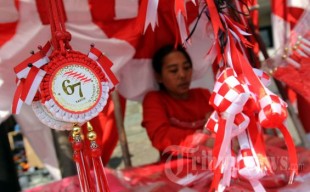 An Indonesian merchant selling her Indonesian flags souvenirs. Many customers buy new flags and souvenirs to welcome Indonesian 67th Independence Day. (Photo: m.tribunnews.com)