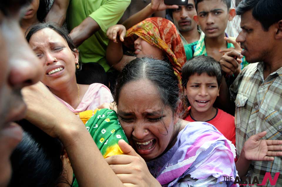 Women cry over a fire accident in slums at the Begunbari area in Dhaka, cap...