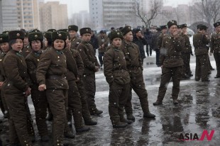 북한 인민군 남녀 병사들이 17일 눈 내리는 평양 시내 한 거리에 편한 자세로 모여 서 있다. <자료사진=AP/뉴시스>