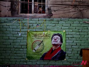 Pakistani opposition leader’s election campaign poster hung on wall