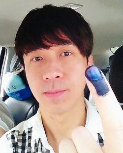 Taiwan based singer Michael Wong showing the indelible ink on his finger after voting in GE13.