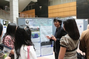 An author in CISAK 2013 explains his research to the participants during Poster Session