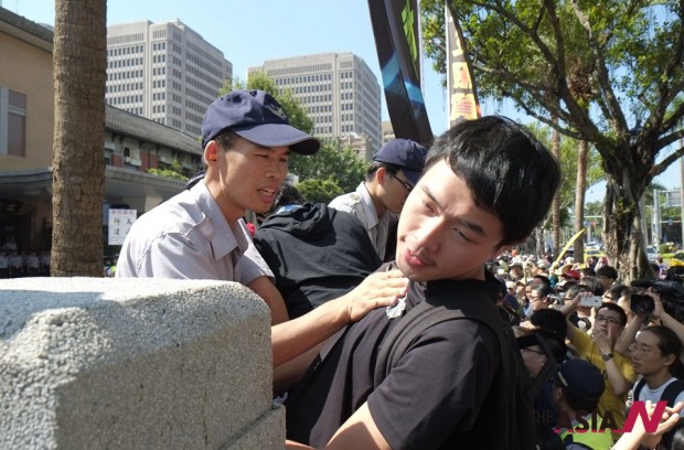 Police push back student protesters as they try to scale the gates of the legislature in defiance of Taiwan's latest trade pact agreement with China, in Taipei, Taiwan, Wednesday, July 31, 2013. The pact, signed between the sides on June 21, allows each to invest in the other's service sectors, including banking. (Photo : AP Photo/Wally Santana)