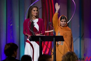 After speaking to attendees, Malala Yousafzai, the Pakistani teenager shot by the Taliban for promoting education for girls, waves to the crowd after receiving the Leadership in Civil Society Award from Queen Rania of Jordan, left, at the Clinton Global Initiative's Citizen Awards Dinner, Wednesday, Sept. 25, 2013, in New York. (NEWSis/AP)