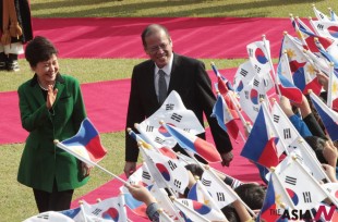 Philippine President Benigno Aquino III, right, and his South Korean counterpart Park Geun-hye greet children waving the two countries' national flags during a welcoming ceremony at the presidential house in Seoul, South Korea, Thursday, Oct. 17, 2013. (AP /NEWSis)