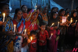 People hold candles during a candlelight vigil for the victims of Rana Plaza collapse at Savar, on the outskirts of Dhaka, Bangladesh, Oct. 24, 2013.(Xinhua/NEWSis)