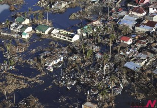 Damaged houses lie in a flooded area in this aerial photo taken from a Philippine Air Force helicopter in typhoon-ravaged Leyte province, central Philippines Monday, Nov. 18, 2013. Hundreds of thousands of people were displaced by Typhoon Haiyan, which tore across several islands in the eastern Philippines on Nov. 8. (AP/NEWSis)