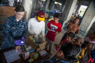 Lt. Lauren Moses, left, from Port Townsend, Wash., a physician assistant aboard the aircraft carrier USS George Washington, helps Philippine nurses treat patients at the Immaculate Conception School in Guiuan, Philippines, Sunday, Nov. 17, 2013. The George Washington Carrier Strike Group is assisting the Philippine government in the aftermath of Typhoon Haiyan in the Republic of the Philippines. (AP/NEWSis)
