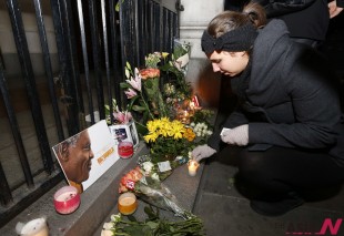 A woman lights a candle for Nelson Mandela outside South African High Commission in London, Friday, Dec. 6, 2013. Mandela, South Africa's first black president, died Thursday in Johannesburg, South Africa after a long illness. He was 95. (AP/NEWSis)