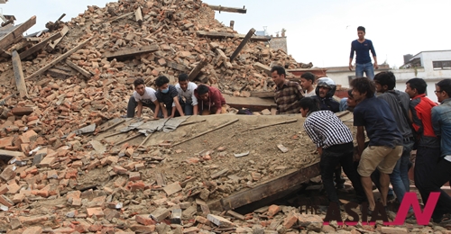  In this April 25, 2015 photo, people try to lift the debris from a temple at Hanumandhoka Durbar Square after an earthquake in Kathmandu, capital of Nepal, Saturday, April 25, 2015. A strong earthquake shook Nepal's capital and the densely populated Kathmandu Valley before noon Saturday, causing extensive damage with toppled walls and collapsed buildings, officials said.