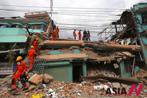  India's National Disaster Response Force personnel look for survivors in a building, in Kathmandu, Nepal, Sunday, April 26, 2015. Sleeping in the streets and shell-shocked, Nepalese cremated the dead and dug through rubble for the missing Sunday, a day after a massive Himalayan earthquake devastated the region and destroyed homes and infrastructure. 
