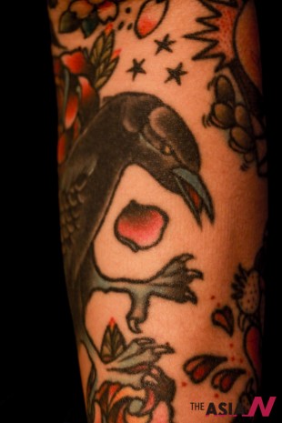 Kay Lee’s arm showing a tattoo of a crow.