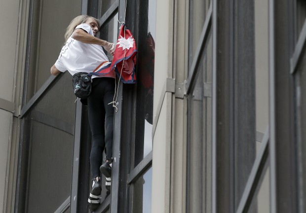 Alain Robert, also known as the French Spiderman, sets up a Nepal flag as he climbs the Montparnasse tower a 210-metre (689 ft) office skyscraper located in the Montparnasse area of Paris, France, Tuesday, April 28, 2015. Robert decided to climb in solidarity with the victims of the Saturday's earthquake in Nepal. (AP Photo)