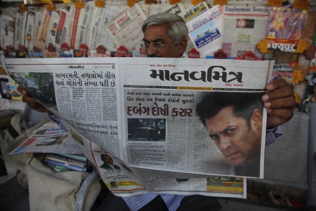 An Indian man reads a newspaper that has the news of Bollywood actor Salman Khans court verdict on the front page in Ahmadabad, India, Wednesday, May 6, 2015. One of India's biggest and most popular movie stars, Khan, was sentenced to five years in jail Wednesday on charges of driving a vehicle over five men sleeping on a sidewalk and killing one in a hit-and-run case that has dragged for more than 12 years. (AP Photo)