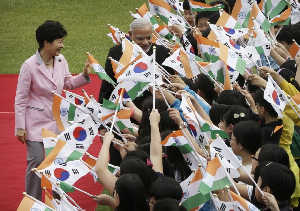 Indian Prime Minister Narendra Modi, center,  and South Korean President Park Geun-hye, left, are greeted by South Korean elementary school students during a welcoming ceremony at the presidential house in Seoul, South Korea, Monday, May 18, 2015.(AP Photo)