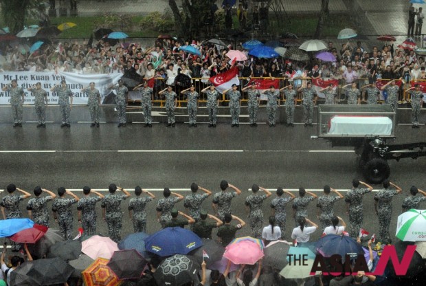 Singaporeans gather along the street as a military gun carriage conveying the coffin of Singapore’s founding father Lee Kuan Yew passes by in Singapore, March 29, 2015. (Photo : Xinhua)