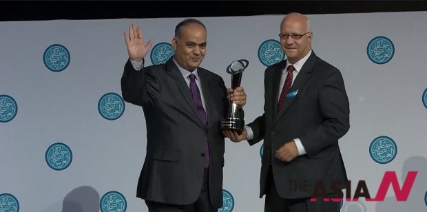 Ashraf Aboul-Yazid, winner of the Cultural Journalism Award, receives the award trophy from Abdul-Elah Belqaziz, AJA board member. 