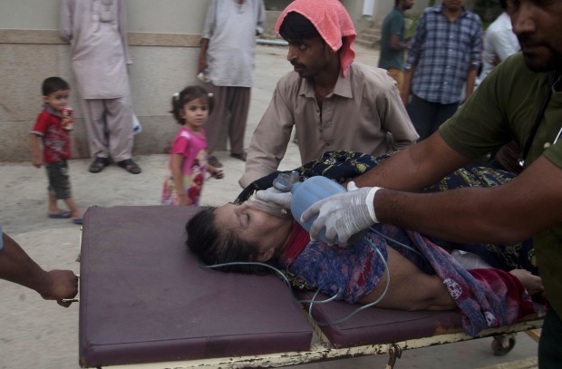 People rush a woman to a hospital as she suffered from a heatstroke in Karachi, Pakistan, Wednesday, June 24, 2015. (AP Photo)