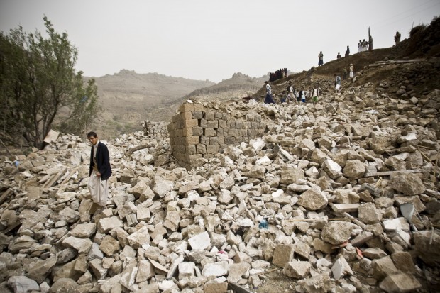 Yemenis stand amid the rubble of houses destroyed by Saudi-led airstrikes in a village near Sanaa, Yemen, Saturday, April 4, 2015. Since their advance began last year, the Shiite rebels, known as Houthis have overrun Yemen's capital, Sanaa, and several provinces, forcing the countrys beleaguered President Abed Rabbo Mansour Hadi to flee the country. A Saudi-led coalition continued to carry out intensive airstrikes overnight and early Saturday morning targeting Houthi positions. (AP Photo)
