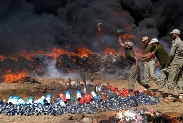 Pakistani officials of the Anti-Narcotic Control Force burn seized drugs and liquor, in Peshawar, Pakistan, Thursday, April 23, 2015. Pakistan is taking strict measures to stop drug trafficking from neighboring Afghanistan and Pakistani tribal areas. (AP Photo)