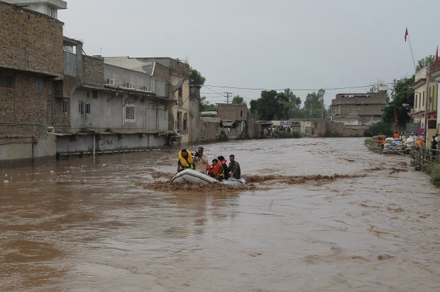 Pakistani volunteers evacuate marooned people after heavy rains in a suburb of Peshawar, Pakistan, Thursday, July 23, 2015. The country's military has deployed helicopters and boats Wednesday to evacuate flood victims, as 285,000 have been affected by monsoon rains and flash floods in and around the city of Chitral in Pakistan's Khyber Pakhtunkhwa province, according to the National Disaster Management Authority. (AP Photo/Mohammad Sajjad)
