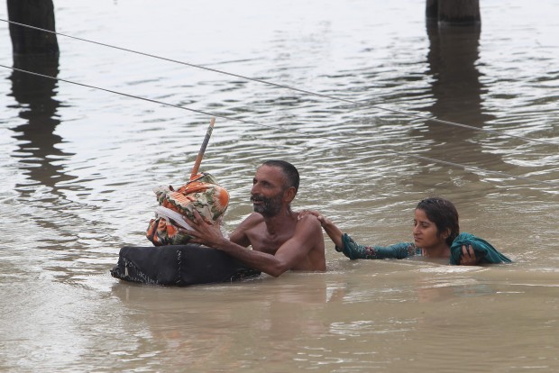 Pakistani villagers wade through floodwaters in Rajanpur, Pakistan, Pakistan, Thursday, July 23, 2015. The country's military has deployed helicopters and boats Wednesday to evacuate flood victims, as 285,000 have been affected by monsoon rains and flash floods in and around the city of Chitral in Pakistan's Khyber Pakhtunkhwa province, according to the National Disaster Management Authority. (AP Photo/Asim Tanveer)