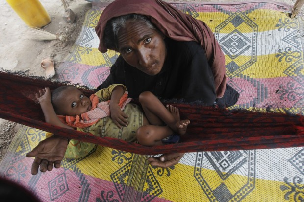 A woman sits with her son after being displaced due to heavy rains in a suburb of Peshawar, Pakistan, Thursday, July 23, 2015. The country's military has deployed helicopters and boats Wednesday to evacuate flood victims, as 285,000 have been affected by monsoon rains and flash floods in and around the city of Chitral in Pakistan's Khyber Pakhtunkhwa province, according to the National Disaster Management Authority. (AP Photo/Mohammad Sajjad)