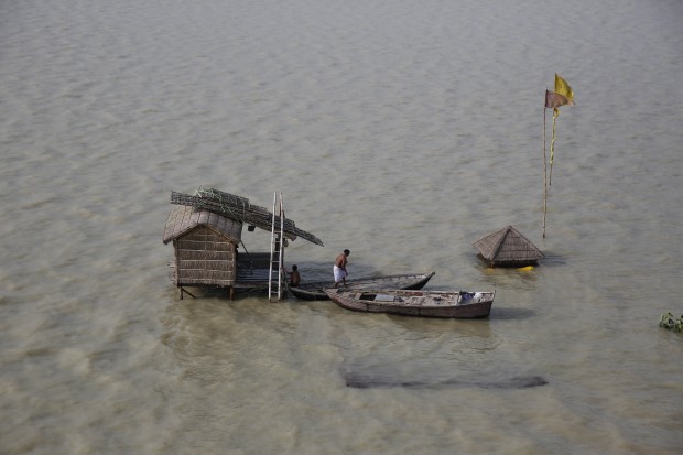 In this July 30, 2015 file photo, a Hindu holy man gets into a boat after the hut where he lives was surrounded by flood waters of the River Ganges in Allahabad, India. The Ganges, one of Indias largest rivers is flooded following monsoon rains. (AP Photo/Rajesh Kumar Singh)