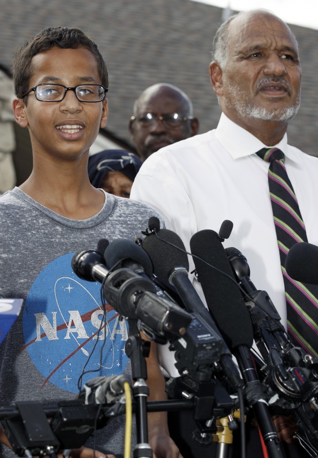 Ahmed Mohamed, 14, left, stands next to his father Mohamed Elhassan Mohamed as he thanks supporters during a news conference at his home, Wednesday, Sept. 16, 2015, in Irving, Texas. Mohamed was arrested after a teacher thought a homemade clock he built was a bomb. (AP Photo/Brandon Wade)