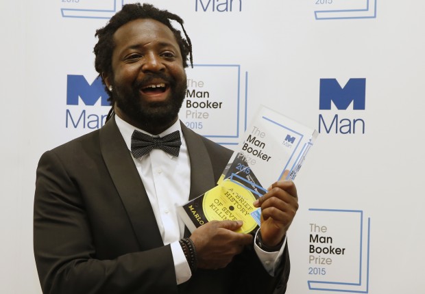 Jamaican author Marlon James holds the award after his book 'A Brief History of Seven Killings' was named as winner of the 2015 Booker Prize 2015 for Fiction, poses for photographers following the award ceremony at the Guildhall in London, Tuesday, Oct. 13, 2015. Marlon James became the first Jamaican winner of the prestigious Booker Prize for fiction Tuesday with a vivid, violent, exuberant and expletive-laden novel based on the 1976 attempted assassination of Bob Marley.(AP Photo/Alastair Grant) 