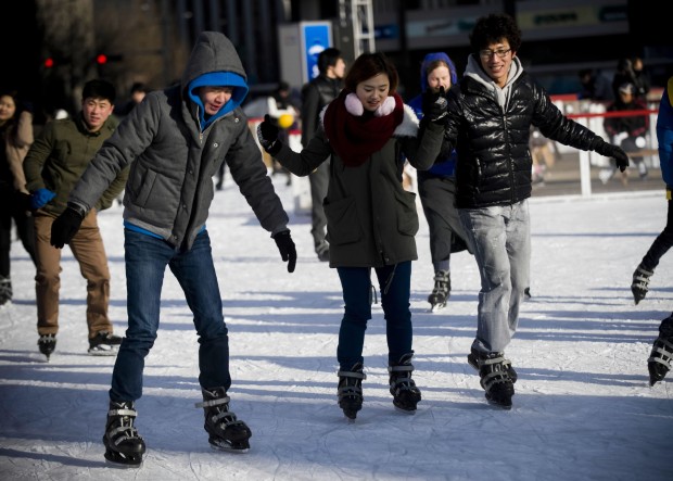 People wearing heavy clothes skate on a rink in Seoul, capital of South Korea. (Xinhua/Lui Siu Wai)