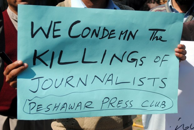 A Pakistani journalist holds a placard during a protest rally against the killing of Mehmood Jan Afridi, who worked for the Urdu-language Intekhab daily in northwest Pakistan's Peshawar, on March 2, 2013. (Xinhua/Umar Qayyum)