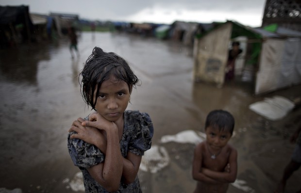 In this June 26, 2014 photo, a girl, self-identified as Rohingya, stands close to her family's tent house at Dar Paing camp for refugees, suburbs of Sittwe, Western Rakhine state, Myanmar. Suu Kyi's many supporters overseas have been dismayed by her silence over the plight of the Rohingya, a Muslim minority who have faced decades of persecution and have only been treated worse since the end of the junta. Rohingya were allowed to vote in 2010, but are being denied in 2015 from voting.(AP Photo/Gemunu Amarasinghe)