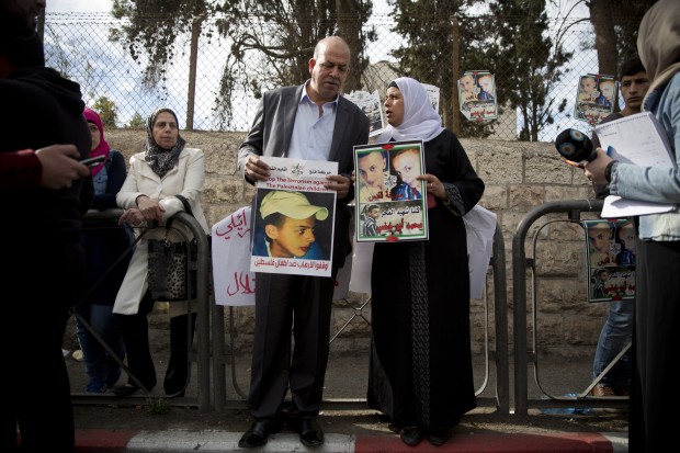 Suha and Hussein Abu Khdeir, center, parents of Mohammed Abu Khdeir, hold posters with his portrait after the reading of the verdict in his killing, at the Jerusalem District Court, Monday, Nov. 30, 2015. The court on Monday convicted two Israeli youths in the grisly killing of Abu Khdeir, while delaying a verdict for 31-year-old Yosef Haim Ben David in the case due to a last-minute insanity plea. The judge determined that Ben David, and two Israeli minors had snatched Abu Khdeir from an east Jerusalem sidewalk in July 2014 and burned him alive in a forest outside the city. (AP Photo/Oded Balilty)