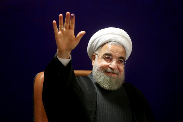 Iran's President Hassan Rouhani, who is also a member of the Experts Assembly, waves to media with an ink-stained finger, after registering his candidacy for the Feb. 26 elections of the assembly at interior ministry in Tehran, Iran, Monday, Dec. 21, 2015. (AP Photo/Ebrahim Noroozi)