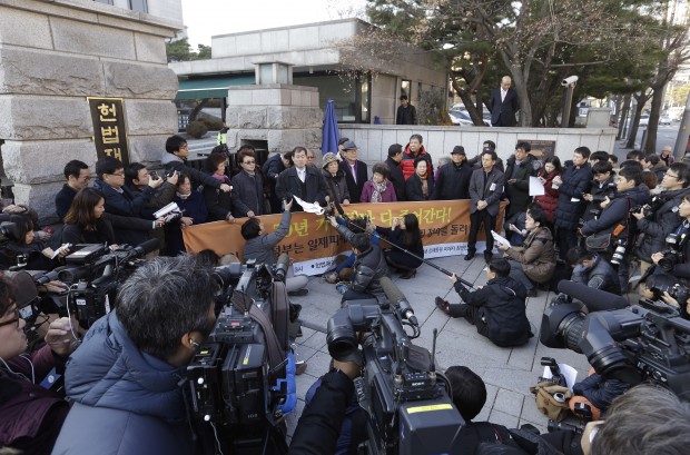 South Korean bereaved family members of victims of World War II hold a press conference in front of the Constitutional Court in Seoul, South Korea, Wednesday, Dec. 23, 2015. The South Korean court on Wednesday refused to review a complaint over the 1965 treaty between Japan and South Korea that Tokyo uses to deny compensation for South Korean victims of World War II-era slavery. (AP Photo/Ahn Young-joon)