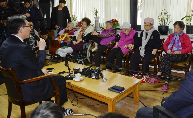South Korean Second Vice Foreign Minister Cho Tae-yul, left, talks to the former South Korean sex slaves, who were forced to serve for the Japanese Army during World War II, at the House of Sharing where the home for the living sex slaves, in Gwangju, South Korea, Tuesday, Dec. 29, 2015. A day after trumpeting an "irreversible" settlement of a decades-long standoff over Korean women forced into sexual slavery by Japan's WWII military, there's relief among South Korean and Japanese diplomats, fury among activists and many of the elderly victims and general public indifference in both countries. (Kim Min-hee/Pool Photo via AP)