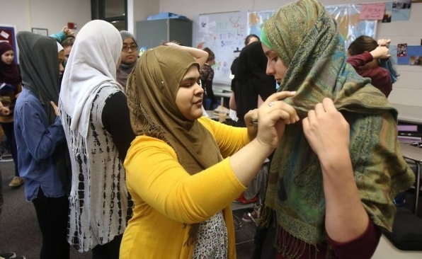 Muslim students helping their non-Muslim friends wear hijab. (youtube video screenshot)
