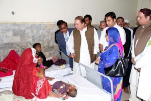 Pakistani Prime Minister Muhammad Nawaz Sharif (2nd L) talks with the patients at a hospital in southern Pakistan's Mithi on March 10, 2014. According to reports, over 120 children lost their lives due to malnutrition as the drought led to a food crisis in southern Pakistan's desert region in Mitthi and Tharparkar. (Xinhua/Stringer)